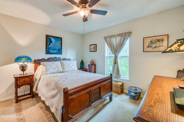 carpeted bedroom featuring ceiling fan and a textured ceiling