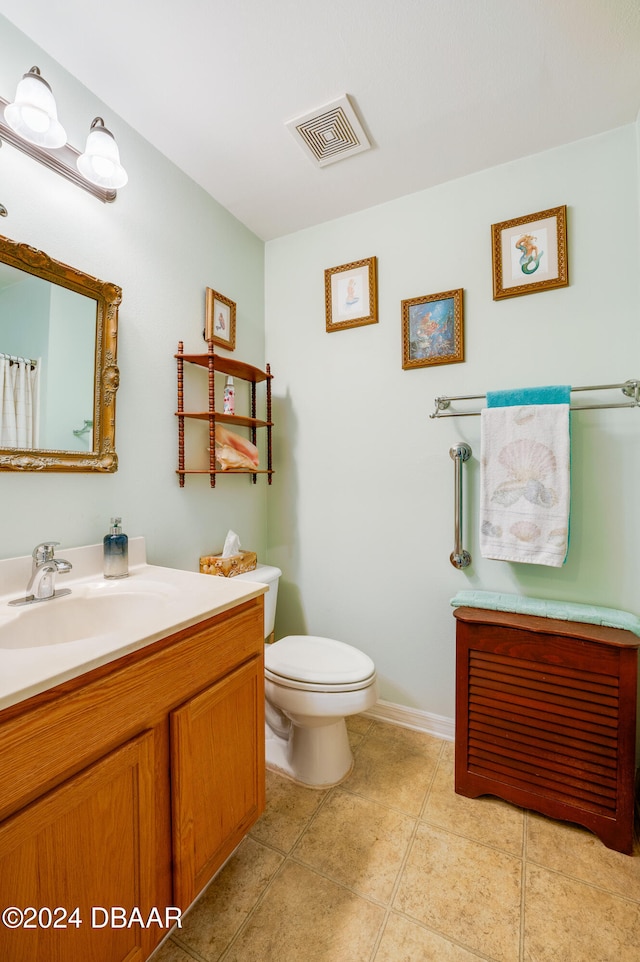 bathroom featuring tile patterned flooring, vanity, and toilet