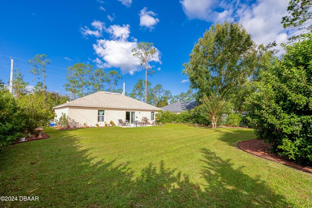 129 Rae Dr, Palm Coast, FL 32164 - view of grassy yard with a patio area