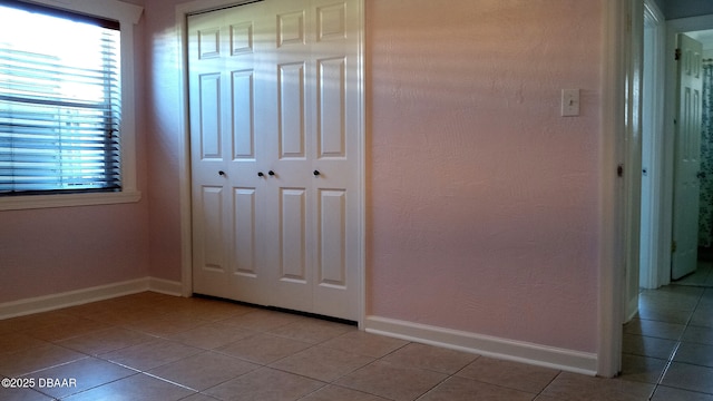 59 Margaret Rd, Ormond Beach, FL 32176 - unfurnished bedroom with light tile patterned floors, multiple windows, baseboards, and a closet