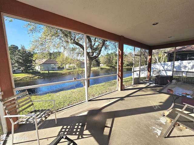 sunroom / solarium featuring a water view