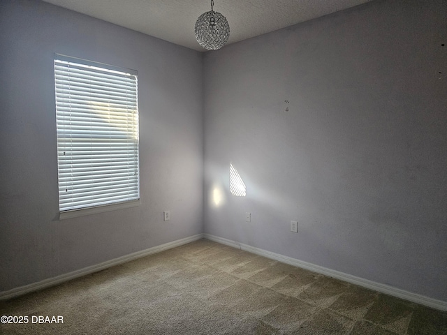 spare room with baseboards and carpet flooring