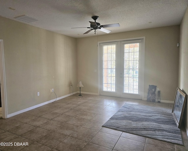 spare room featuring french doors, baseboards, visible vents, and a ceiling fan