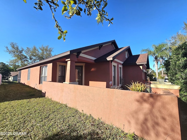 view of property exterior with a fenced front yard and stucco siding