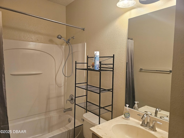 full bathroom with shower / bath combination with curtain, toilet, vanity, and a textured wall