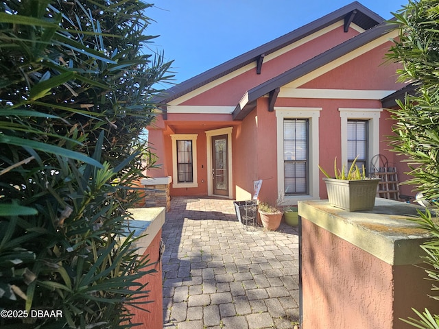 view of exterior entry with stucco siding