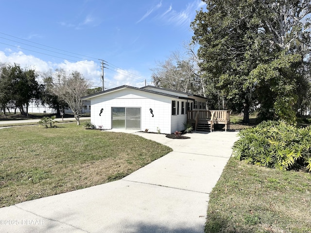 view of side of property with a deck and a lawn