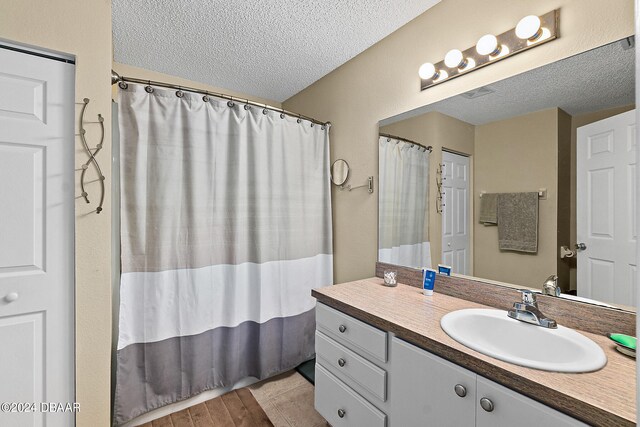 bathroom with vanity, hardwood / wood-style floors, and a textured ceiling