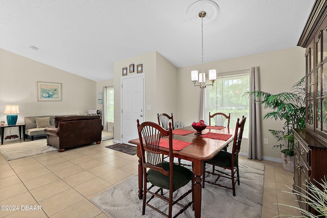 tiled dining room with lofted ceiling, a textured ceiling, and a notable chandelier