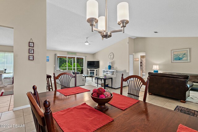 dining space with lofted ceiling, a textured ceiling, a notable chandelier, and light tile patterned floors