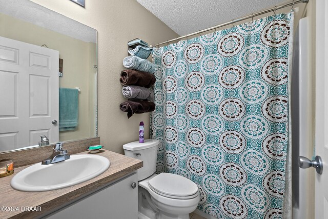 bathroom with toilet, vanity, and a textured ceiling