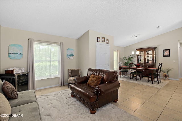 dining space with light tile patterned floors, vaulted ceiling, and an inviting chandelier