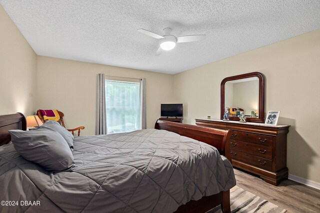 bedroom featuring a textured ceiling, light hardwood / wood-style flooring, and ceiling fan