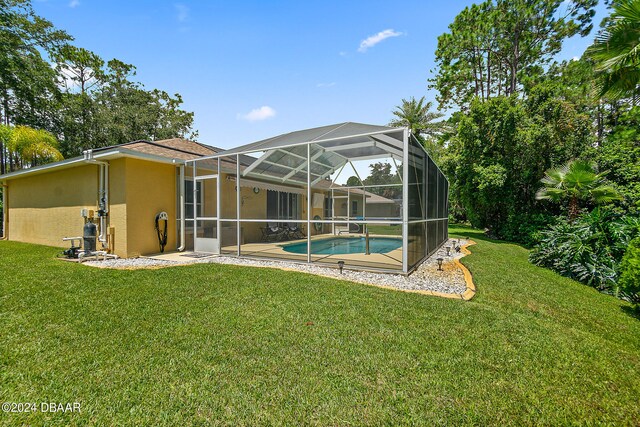 back of property featuring glass enclosure and a yard