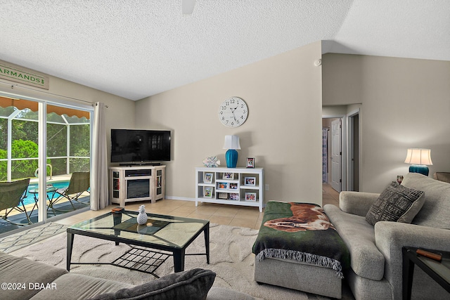 living room with lofted ceiling, a textured ceiling, and light tile patterned flooring