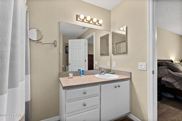 bathroom featuring wood-type flooring, a textured ceiling, and vanity