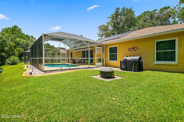 rear view of property featuring glass enclosure, a yard, and a patio