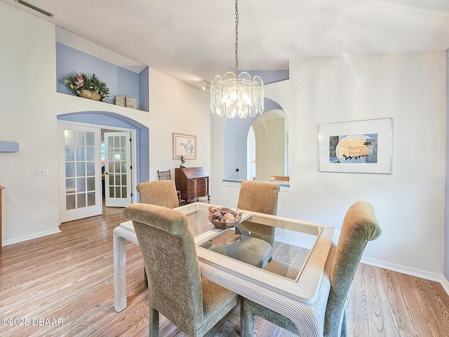 900 Smokerise Blvd, Port Orange, FL 32127 - dining space featuring arched walkways, a chandelier, baseboards, and light wood-style floors