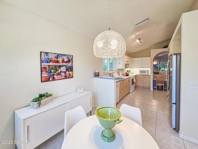 900 Smokerise Blvd, Port Orange, FL 32127 - dining space featuring a chandelier, light tile patterned flooring, a textured ceiling, arched walkways, and lofted ceiling
