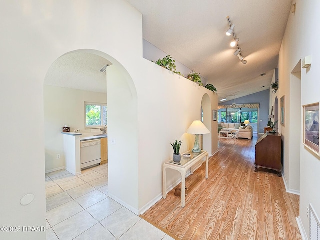 900 Smokerise Blvd, Port Orange, FL 32127 - corridor with arched walkways, healthy amount of natural light, vaulted ceiling, a sink, and a textured ceiling