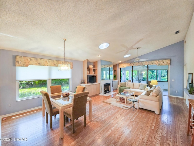 900 Smokerise Blvd, Port Orange, FL 32127 - dining space featuring a textured ceiling, healthy amount of natural light, vaulted ceiling, light wood-style floors, and baseboards