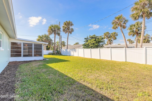 view of yard with a sunroom and a fenced backyard