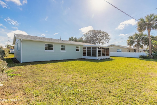 back of house with a sunroom, fence, and a yard