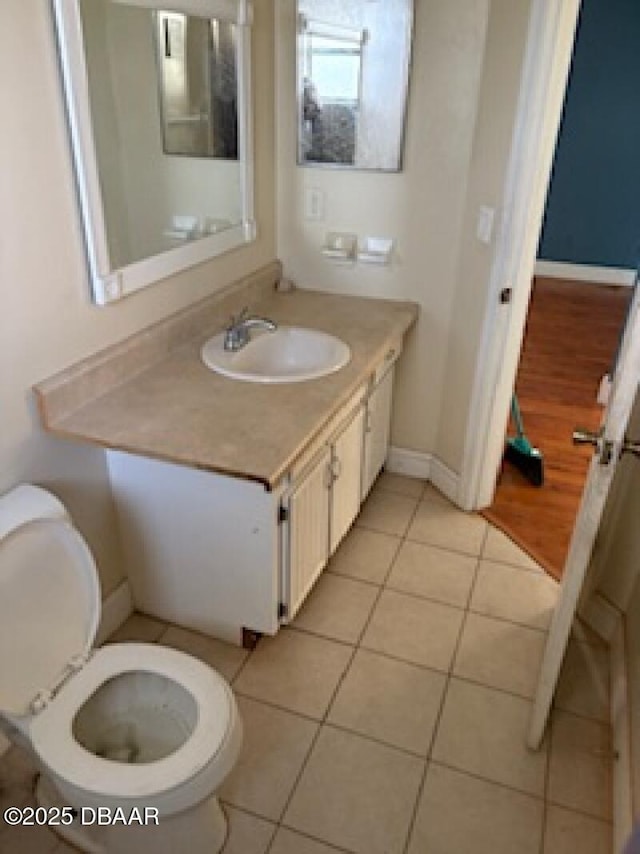 bathroom with vanity, tile patterned floors, baseboards, and toilet