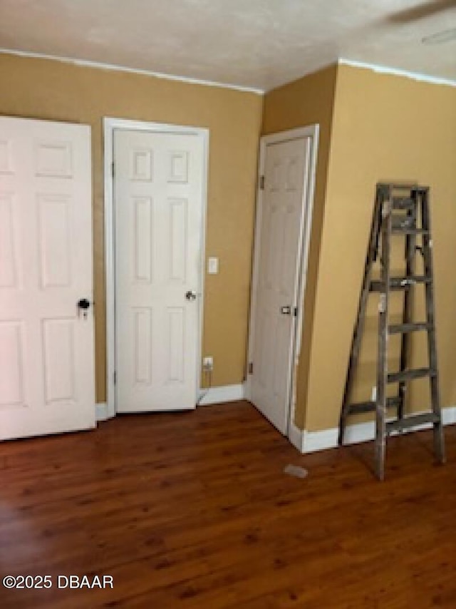 unfurnished bedroom with baseboards and wood finished floors