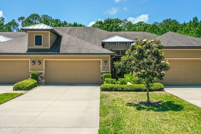 view of front of home with a front lawn and a garage