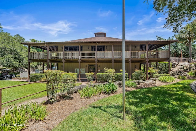 back of house with a deck and a lawn