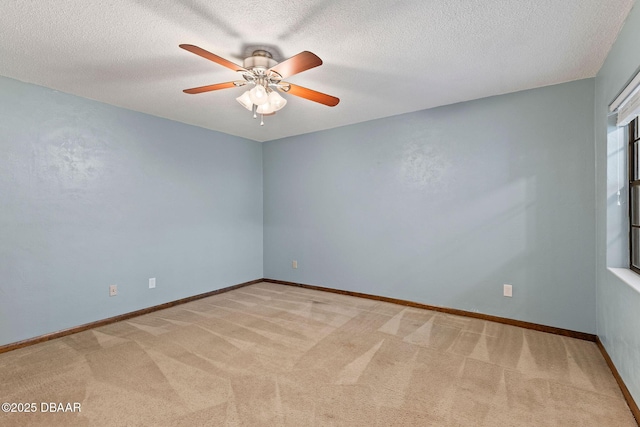 carpeted spare room with a ceiling fan, baseboards, and a textured ceiling