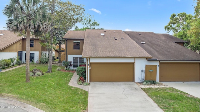 view of front facade featuring a front lawn, an attached garage, concrete driveway, and roof with shingles