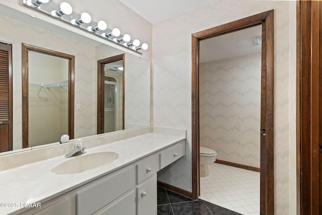 full bathroom featuring tile patterned floors, toilet, vanity, baseboards, and wallpapered walls