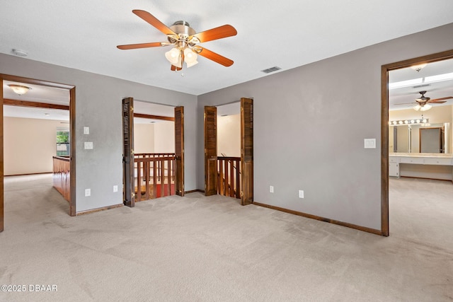 unfurnished bedroom featuring light carpet, baseboards, ceiling fan, and visible vents