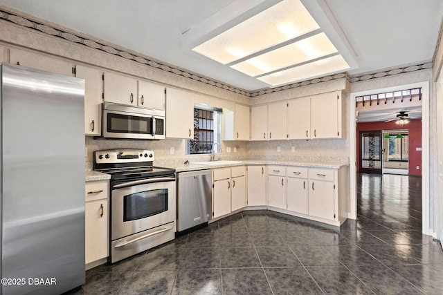 kitchen featuring light countertops, a sink, backsplash, and appliances with stainless steel finishes
