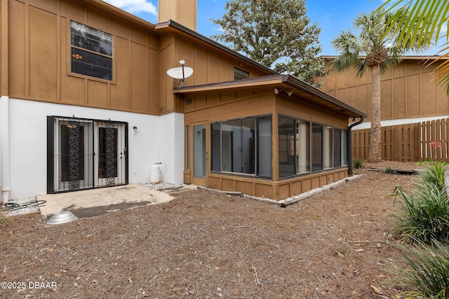 back of house featuring a sunroom and fence