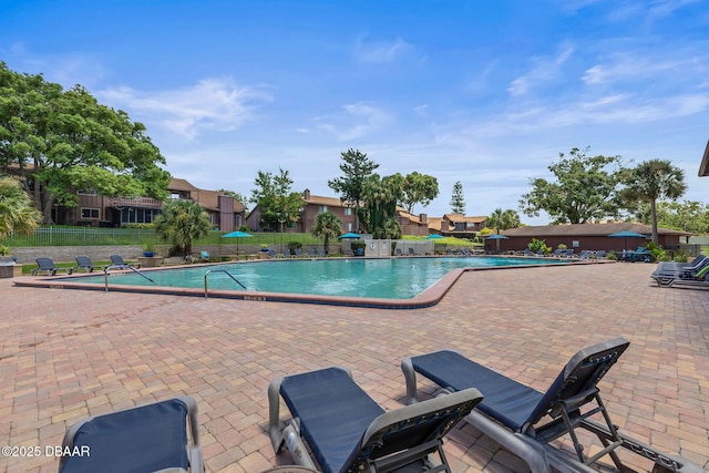 pool with a patio and fence