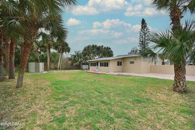 view of yard with a storage shed and a patio