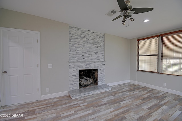 unfurnished living room with light hardwood / wood-style flooring, a fireplace, and ceiling fan