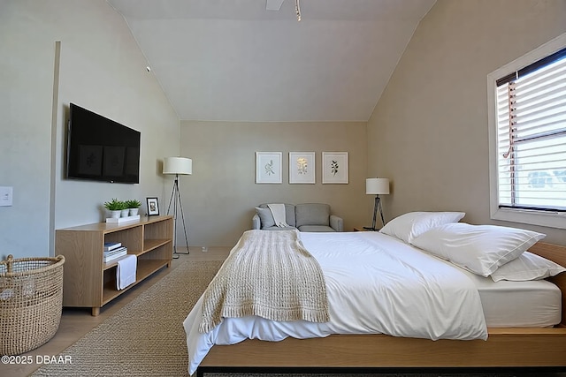 bedroom featuring vaulted ceiling and light wood-type flooring