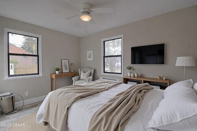 bedroom featuring baseboards, ceiling fan, and wood finished floors