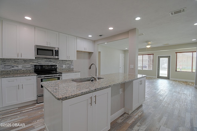 kitchen featuring white cabinetry, an island with sink, appliances with stainless steel finishes, and sink