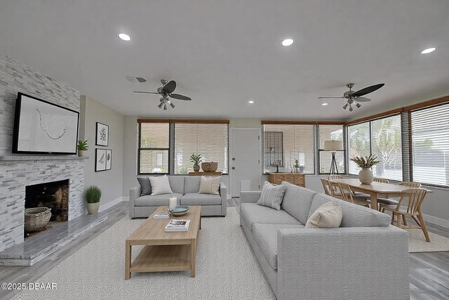 unfurnished living room featuring a fireplace, light hardwood / wood-style floors, and ceiling fan