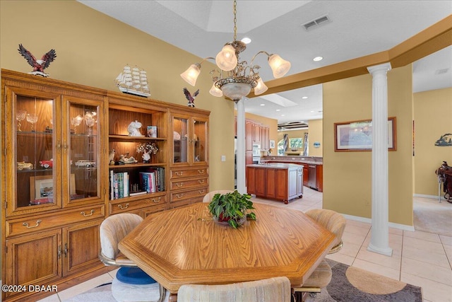 tiled dining room featuring a chandelier and ornate columns