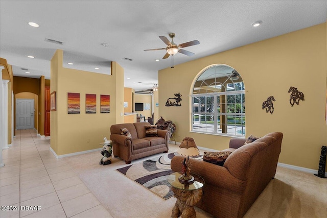 tiled living room with ceiling fan and a textured ceiling