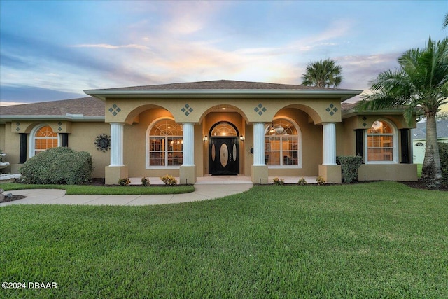 mediterranean / spanish home with a lawn