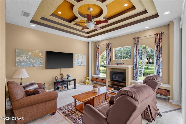 carpeted living room with a raised ceiling and ceiling fan