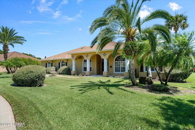 mediterranean / spanish house featuring a front lawn