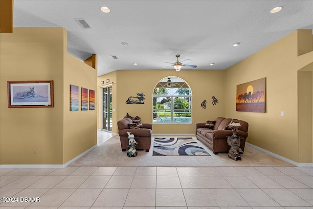 living room with light tile patterned floors, a textured ceiling, and ceiling fan